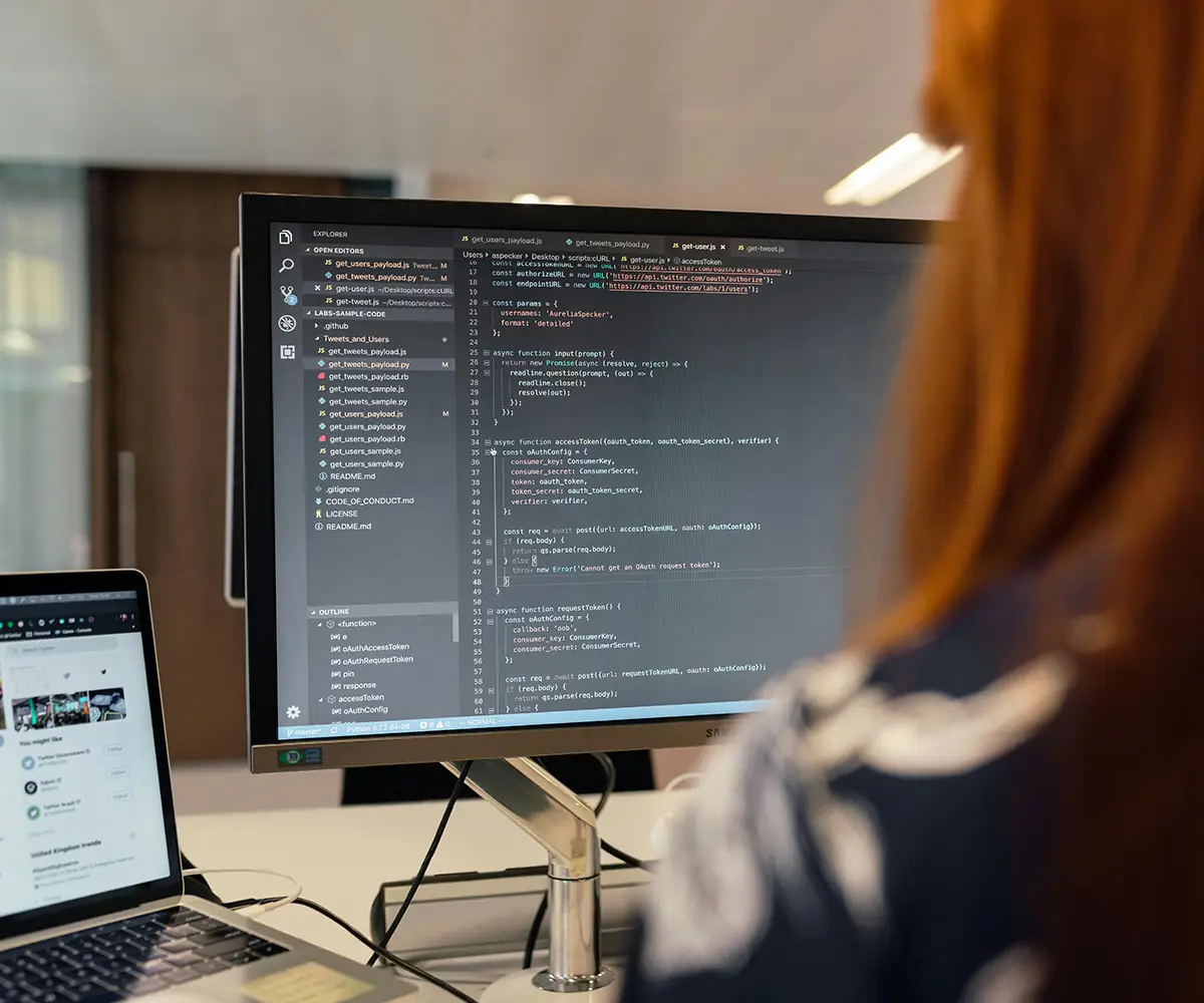 Una impiegata vista di spalle lavora davanti al monitor di un computer.